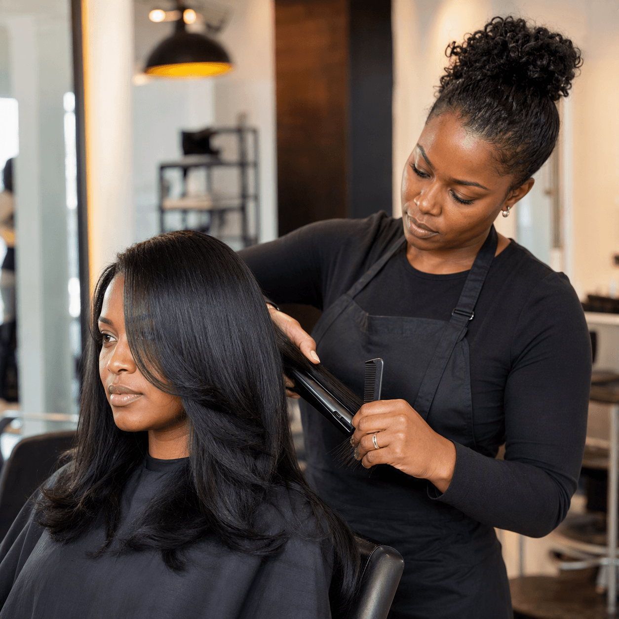 Silk press service with flat iron styling in progress